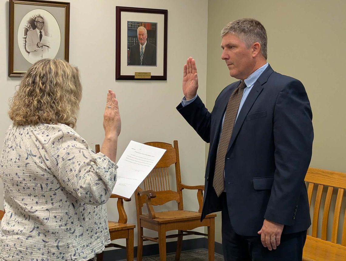 Sigler Sworn In As Interim Mayor Photo of David Sigler, a white man in his 40s wearing a dark blue suit, light blue shirt and brown tie standing with his right hand raised as he takes the oath of office in the Lexington City Circuit Court Clerk's office