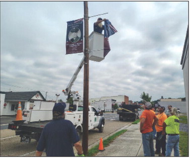 A BUENA VISTA public works employee hangs two banners honoring Vietnam veterans on Magnolia Avenue Tuesday morning. The American Legion has 32 banners ready for hanging, and the city is midway through installing them. (photo by Aiden Kelsey)